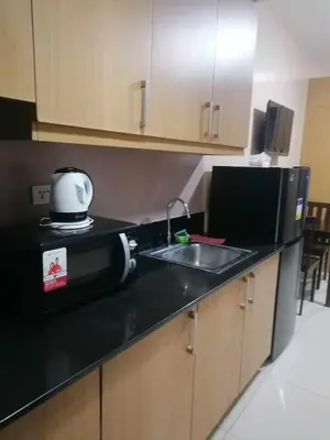 a kitchen with a sink and a toaster and a microwave at Location perfect staycation with Netflix in Manila