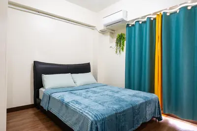 a bedroom with a bed and curtains in a room at 2 bed room in Fairlane Residences Pasig in Manila