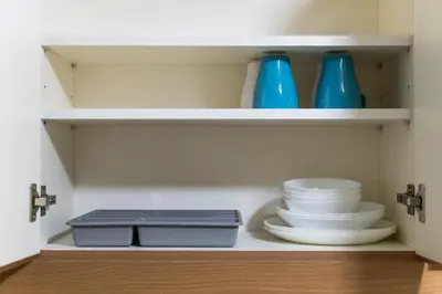 a closet with plates and bowls and blue vases at 2 bed room in Fairlane Residences Pasig in Manila