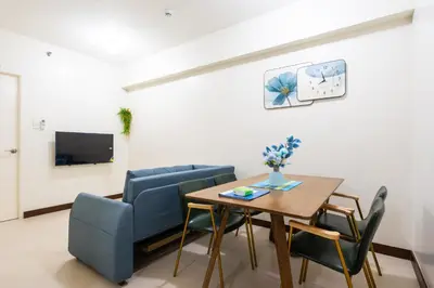a living room with a table and chairs and a tv at 2 bed room in Fairlane Residences Pasig in Manila
