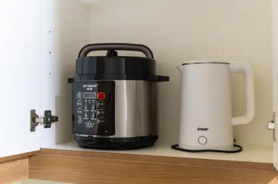 a slow cooker and a toaster sitting on a shelf at 2 bed room in Fairlane Residences Pasig in Manila