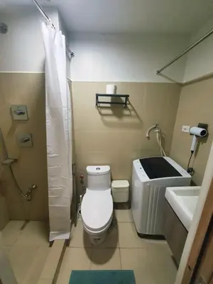 a bathroom with a toilet and a sink at Minimalist Big 1BR Pool View MOA Airport in Manila