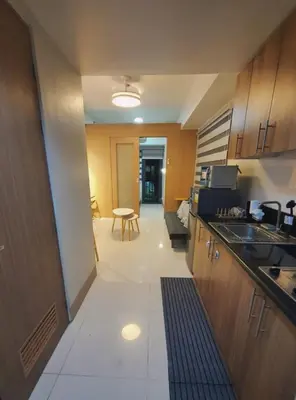 a kitchen with a sink and a counter top at Minimalist Big 1BR Pool View MOA Airport in Manila