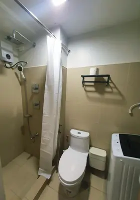 a bathroom with a toilet and a shower at Minimalist Big 1BR Pool View MOA Airport in Manila