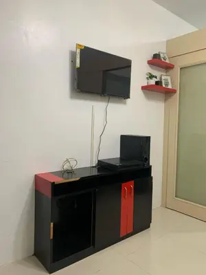 a black entertainment center with a television on a wall at Sea Residences by Estelle in Manila