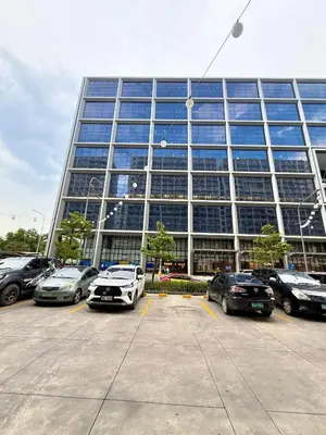 a large building with cars parked in a parking lot at Biens Staycation at SHORE Residences near Mall of Asia in Manila