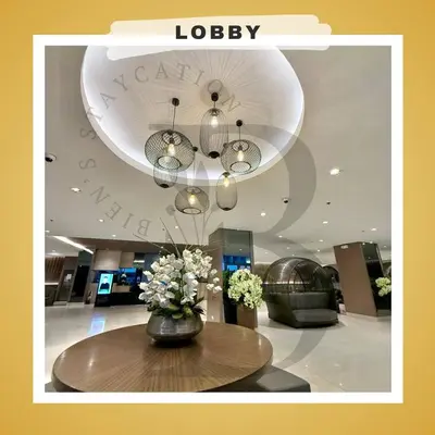 a lobby with a table with a vase of flowers at Biens Staycation at SHORE Residences near Mall of Asia in Manila