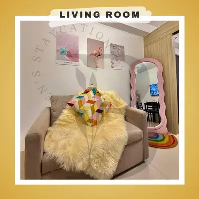 a living room with a brown couch with a furry pillow at Biens Staycation at SHORE Residences near Mall of Asia in Manila