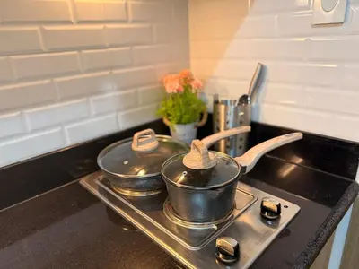 two pots and pans on a stove in a kitchen at Classy Spacious flat Shore2 Mall of Asia Pasay in Manila