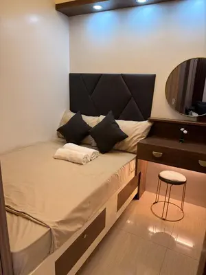 a bed in a small room with a mirror at Classy Spacious flat Shore2 Mall of Asia Pasay in Manila