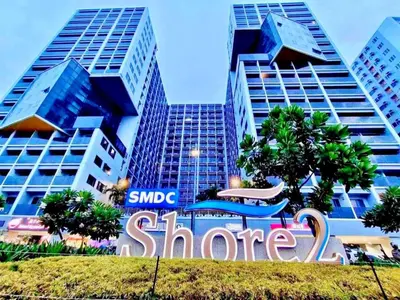 a store sign in front of some tall buildings at Golden Shore Haven - Pasay in Manila