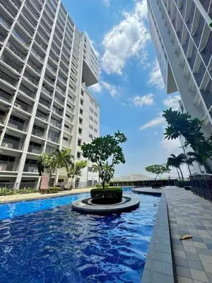a swimming pool in front of a large building at Golden Shore Haven - Pasay in Manila