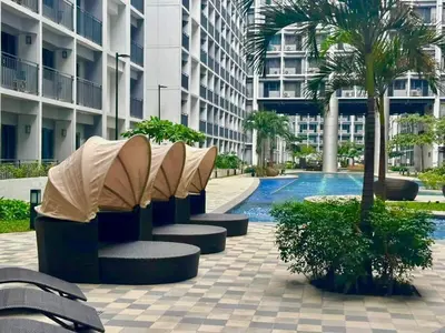 a courtyard with benches and a pool in a building at Golden Shore Haven - Pasay in Manila