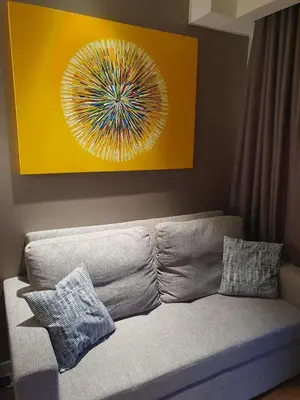 a couch in a living room with a painting on the wall at Novotel Hotel Residences at Acqua- AMOREsuite in Manila