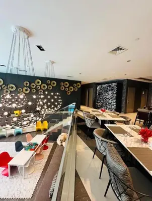 a restaurant with tables and chairs in a room at Novotel Hotel Residences at Acqua- AMOREsuite in Manila