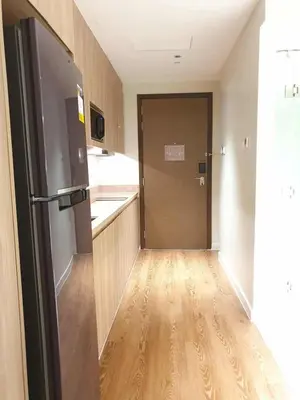 a kitchen with a hallway with a refrigerator and wooden floors at Novotel Hotel Residences at Acqua- AMOREsuite in Manila