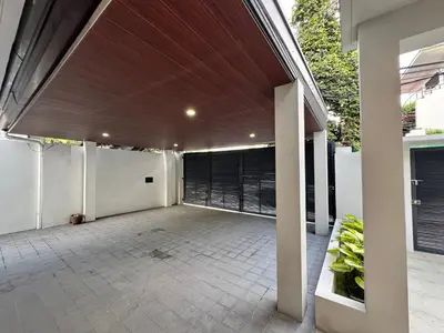 an outdoor patio with a wooden ceiling and white walls at Halika Villa & Capitolo events place near BGC in Manila