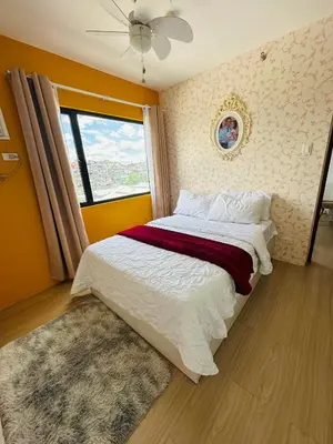a bedroom with a large bed with a window at Tower C 3rd Floor in Taytay