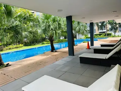 an outdoor patio with a swimming pool and palm trees at Tower C 3rd Floor in Taytay