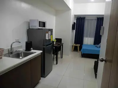 a small kitchen with a sink and a refrigerator at Tabatina Grand Reviera Suites in Manila
