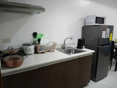 a kitchen with a sink and a refrigerator at Tabatina Grand Reviera Suites in Manila
