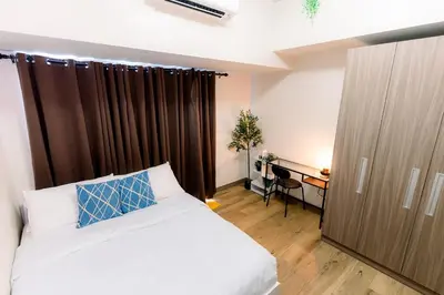 a bedroom with a bed and a desk in it at Cozy 1BR Condo in McKinley West in Manila