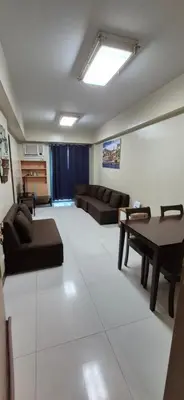 a living room with a couch and a table at Rqui Condotel Rooms Near Airports and Newport World Casino in Manila