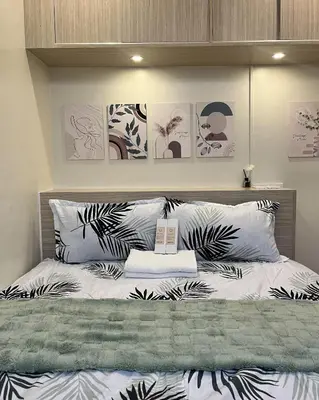 a bedroom with a bed with black and white pillows at Mazal Residence in Manila