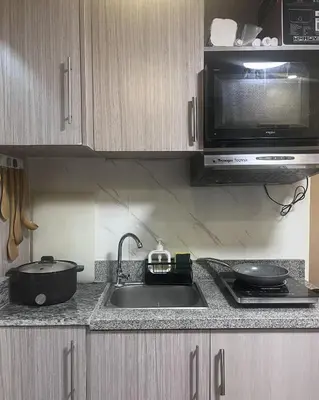 a kitchen counter with a sink and a microwave at Mazal Residence in Manila