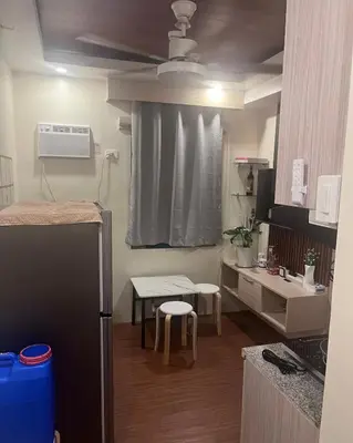 a small kitchen with a refrigerator and a table at Mazal Residence in Manila