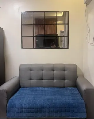 a blue couch in a room with a window at Mazal Residence in Manila