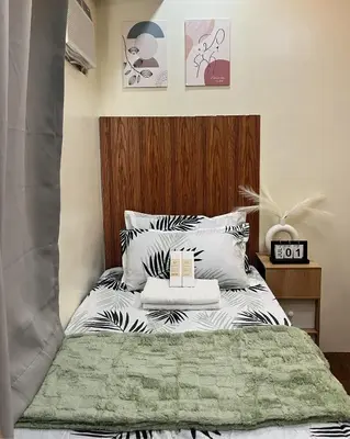 a bedroom with a bed with black and white pillows at Mazal Residence in Manila