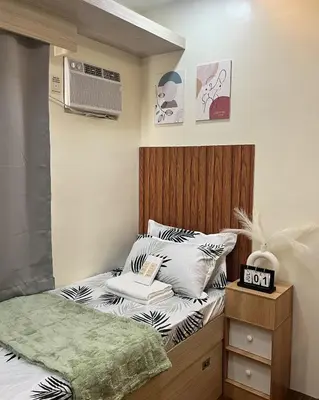 a small bedroom with a bed and a air conditioner at Mazal Residence in Manila