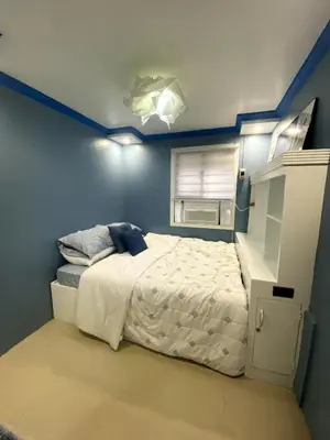 a bedroom with a bed and a blue wall at The Blue Unit - By H&A in Manila