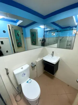 a bathroom with a white toilet and a sink at The Blue Unit - By H&A in Manila
