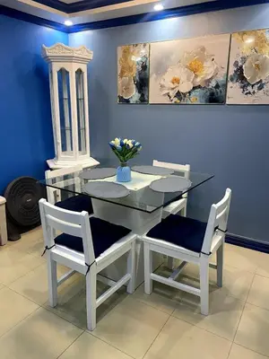 a glass table with two chairs and a vase with flowers at The Blue Unit - By H&A in Manila