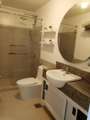 a bathroom with a toilet and a sink and a mirror at Sweet Condo in Manila