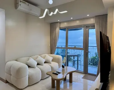 a living room with a white couch and a balcony at Panoramic Seaview 2BR near Airport Facing the Bay 6G in Manila