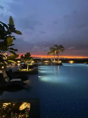 a view of a pool at a resort at night at Panoramic Seaview 2BR near Airport Facing the Bay 6G in Manila