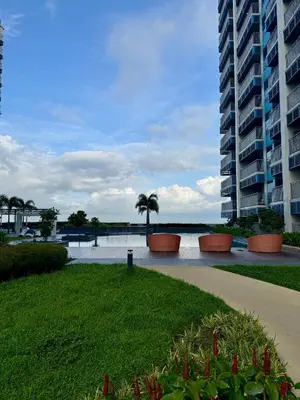 a walkway next to a large building with a palm tree at Panoramic Seaview 2BR near Airport Facing the Bay 6G in Manila