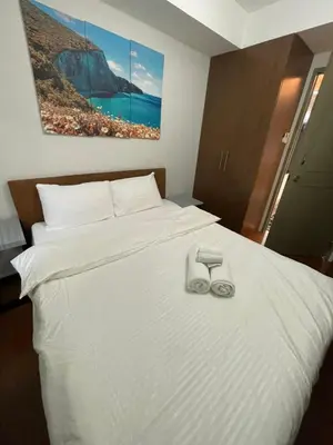 a bedroom with a bed with two slippers on it at Antel Spa Residences 1908 in Manila