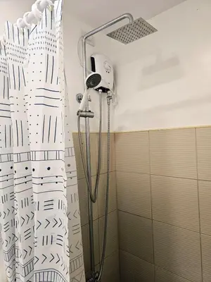 a shower in a bathroom with a shower curtain at Modern Cozy Studio in Dasmariñas