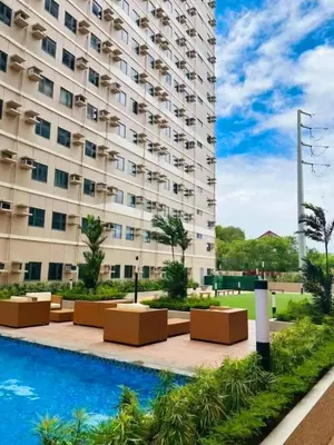 a hotel with a pool in front of a building at Modern Cozy Studio in Dasmariñas