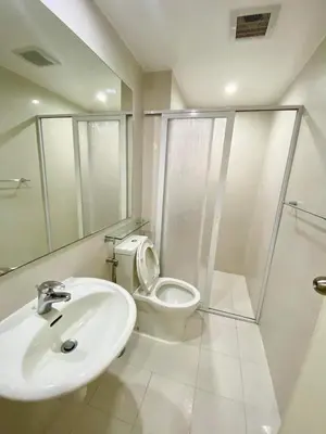a white bathroom with a toilet and a sink at Azure Daily in Manila
