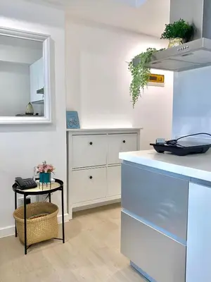 a white kitchen with a counter and a mirror at Azure Daily in Manila