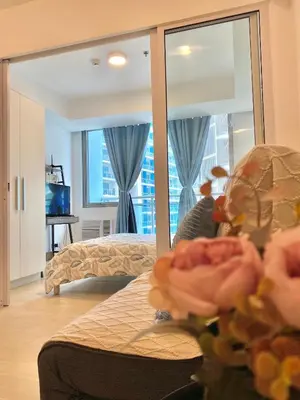 a bedroom with a bed and a large mirror at Azure Daily in Manila
