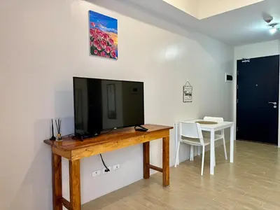a television on a wooden table in a room at Naia T3 Condotel in Manila