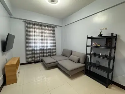 a living room with a couch and a television at Newport City Home- Naia T3 in Manila