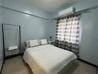 a bedroom with a white bed and a window at Newport City Home- Naia T3 in Manila