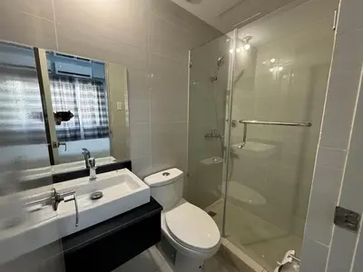 a bathroom with a toilet and a sink and a shower at Newport City Home- Naia T3 in Manila